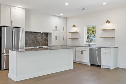 a kitchen with stainless steel appliances a sink and a refrigerator