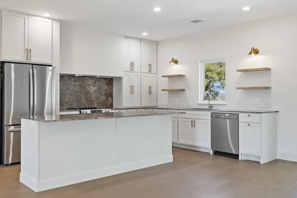 a kitchen with stainless steel appliances a sink and a refrigerator