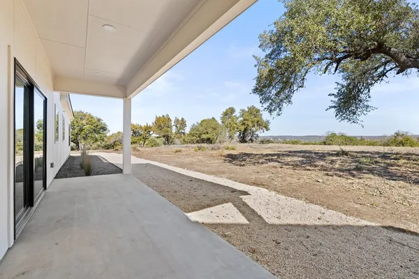 a view of an empty room and kitchen view