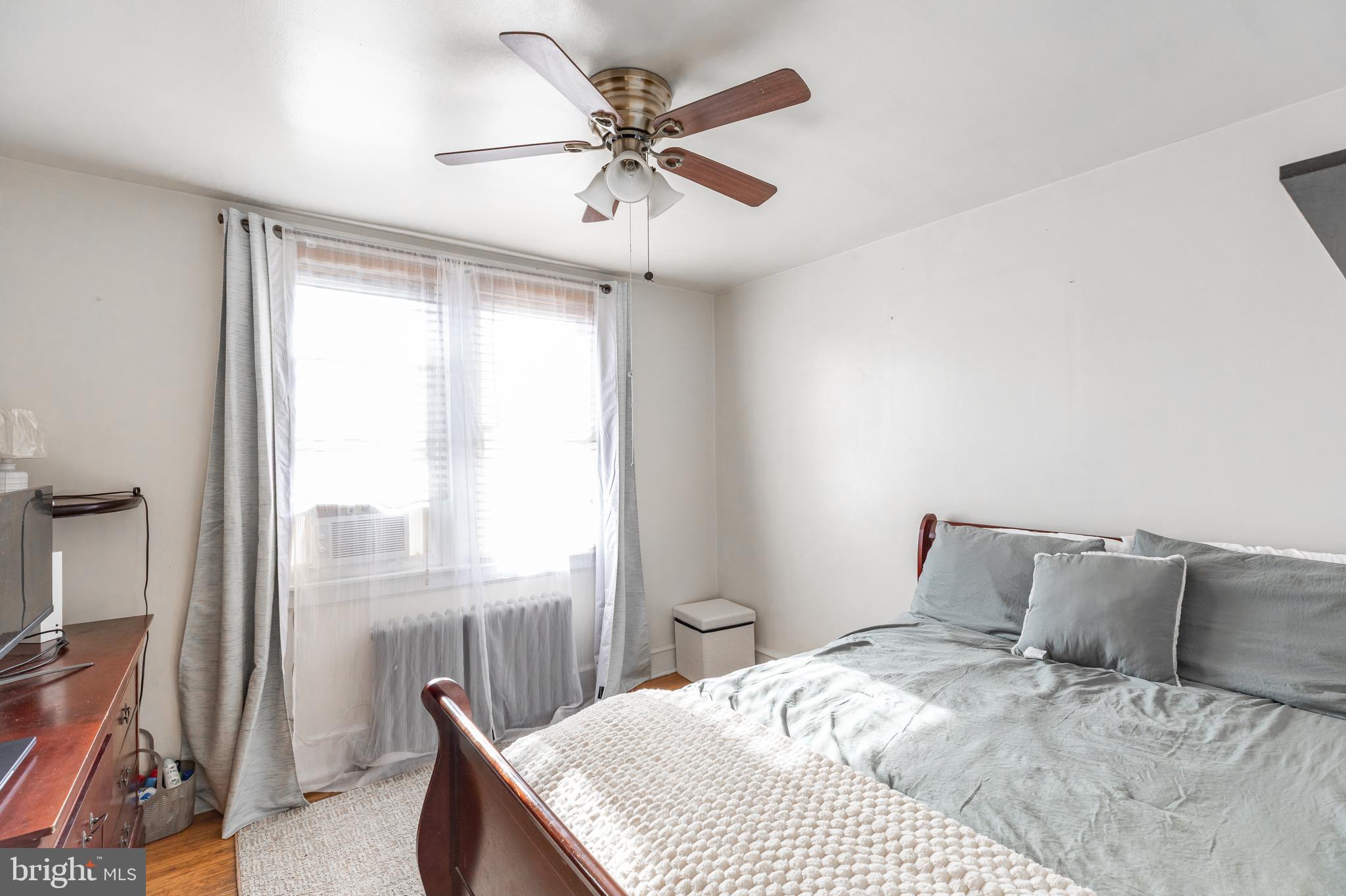 578 Rosalie Street, Unit A Philadelphia, PA 19120 - Photo 13 of 14 a bedroom with a bed and a large window