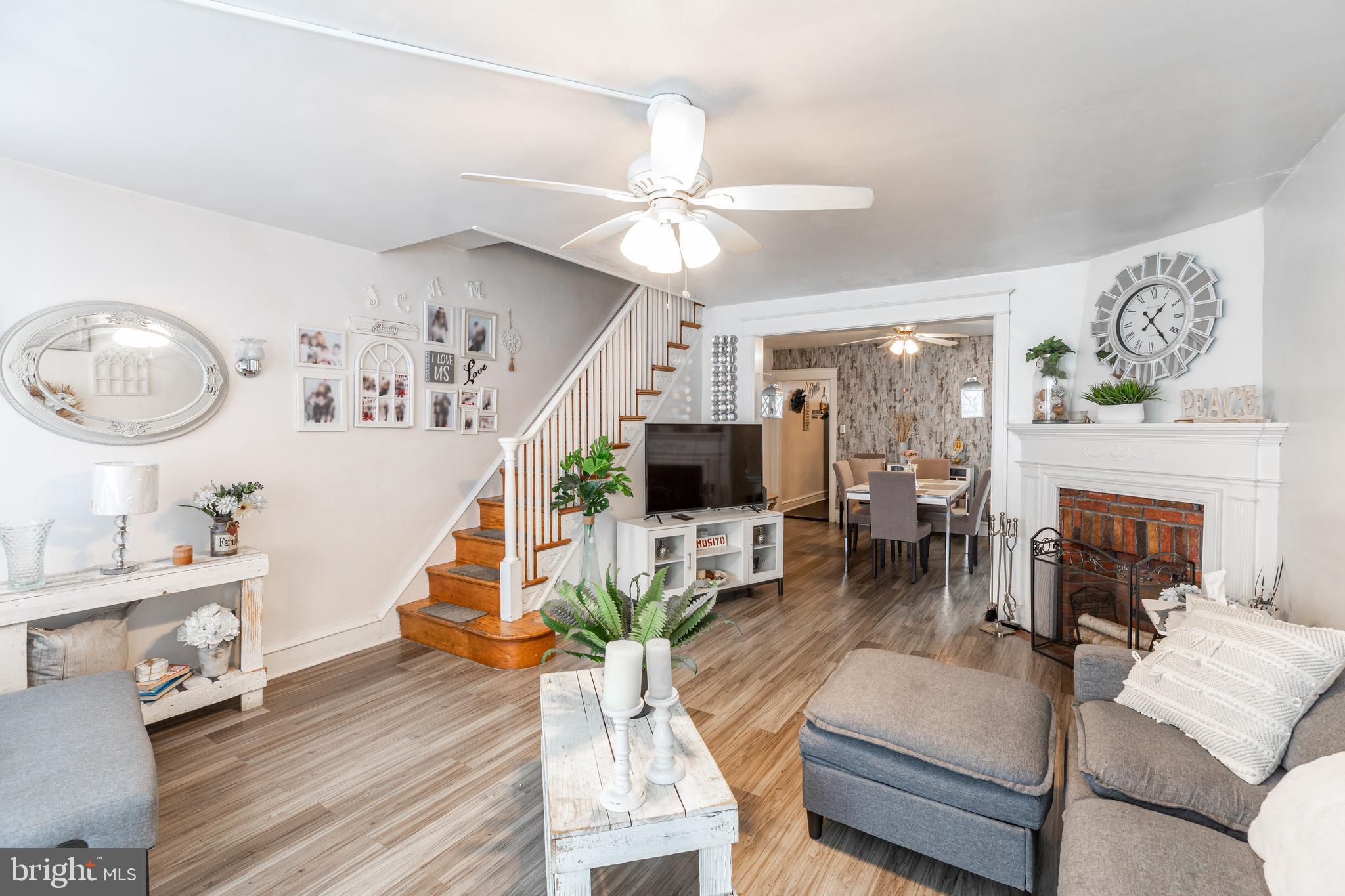 578 Rosalie Street, Unit A Philadelphia, PA 19120 - Photo 2 of 14 a living room with furniture a fireplace and a flat screen tv