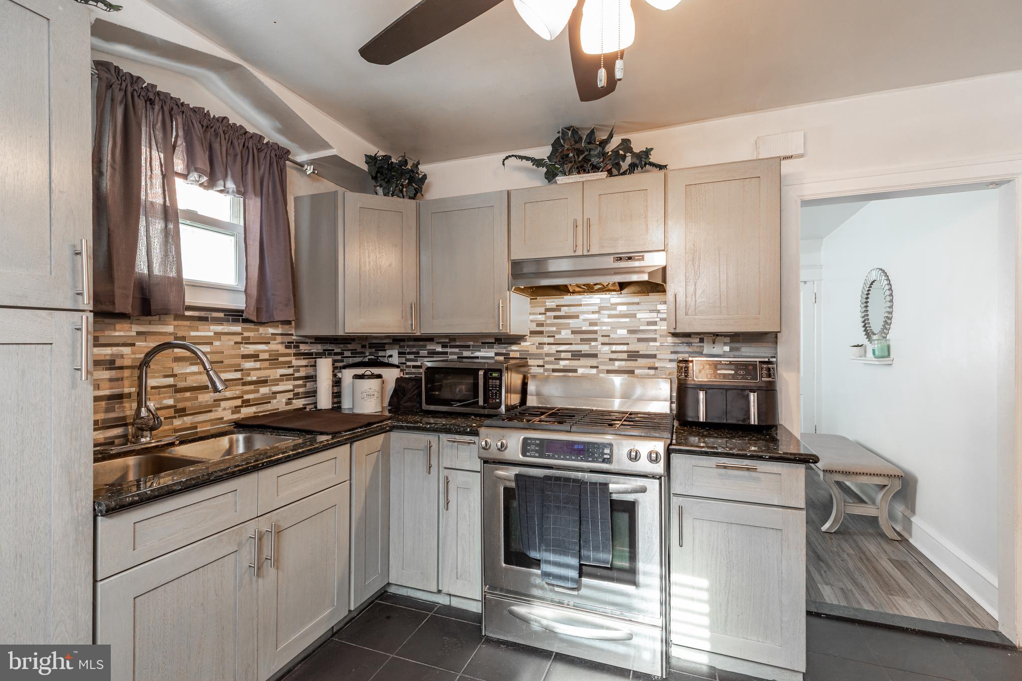 578 Rosalie Street, Unit A Philadelphia, PA 19120 - Photo 6 of 14 a kitchen with stainless steel appliances granite countertop a sink a stove and cabinets