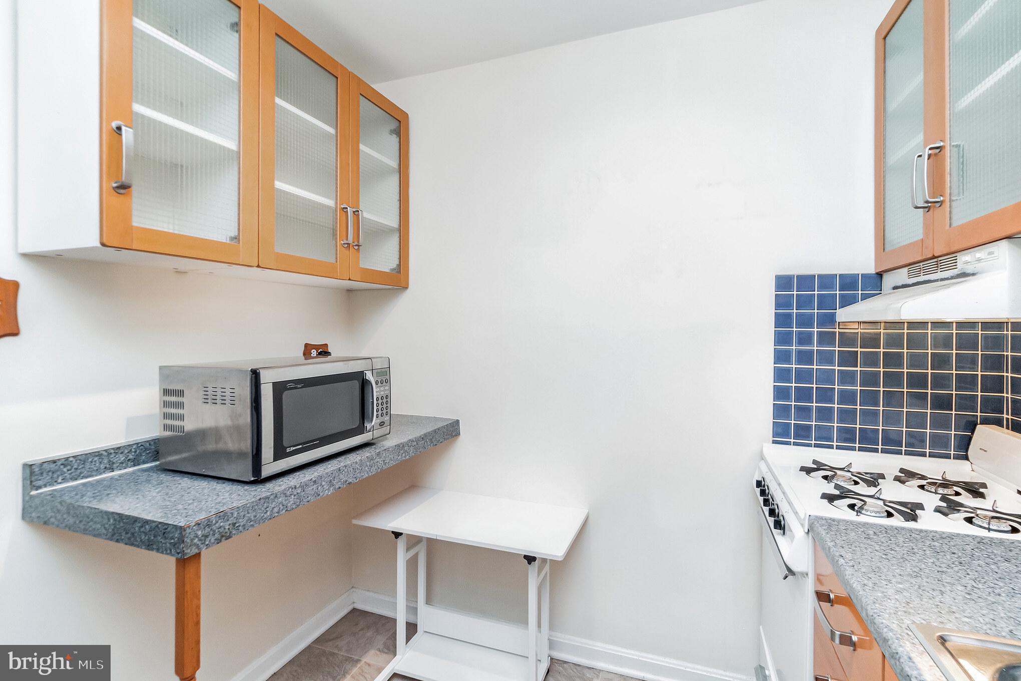 1420 N Street Northwest, Unit 605 Washington, DC 20005 - Photo 7 of 14 a kitchen with stainless steel appliances granite countertop a stove and a microwave