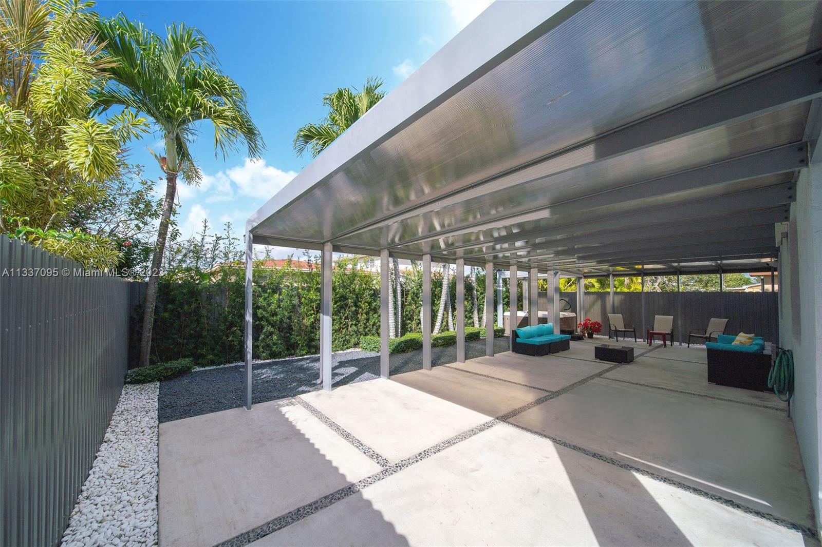 3436 Southwest 88th Place Miami, FL 33165 - Photo 16 of 43 a view of a patio with table and chairs potted plants with palm trees