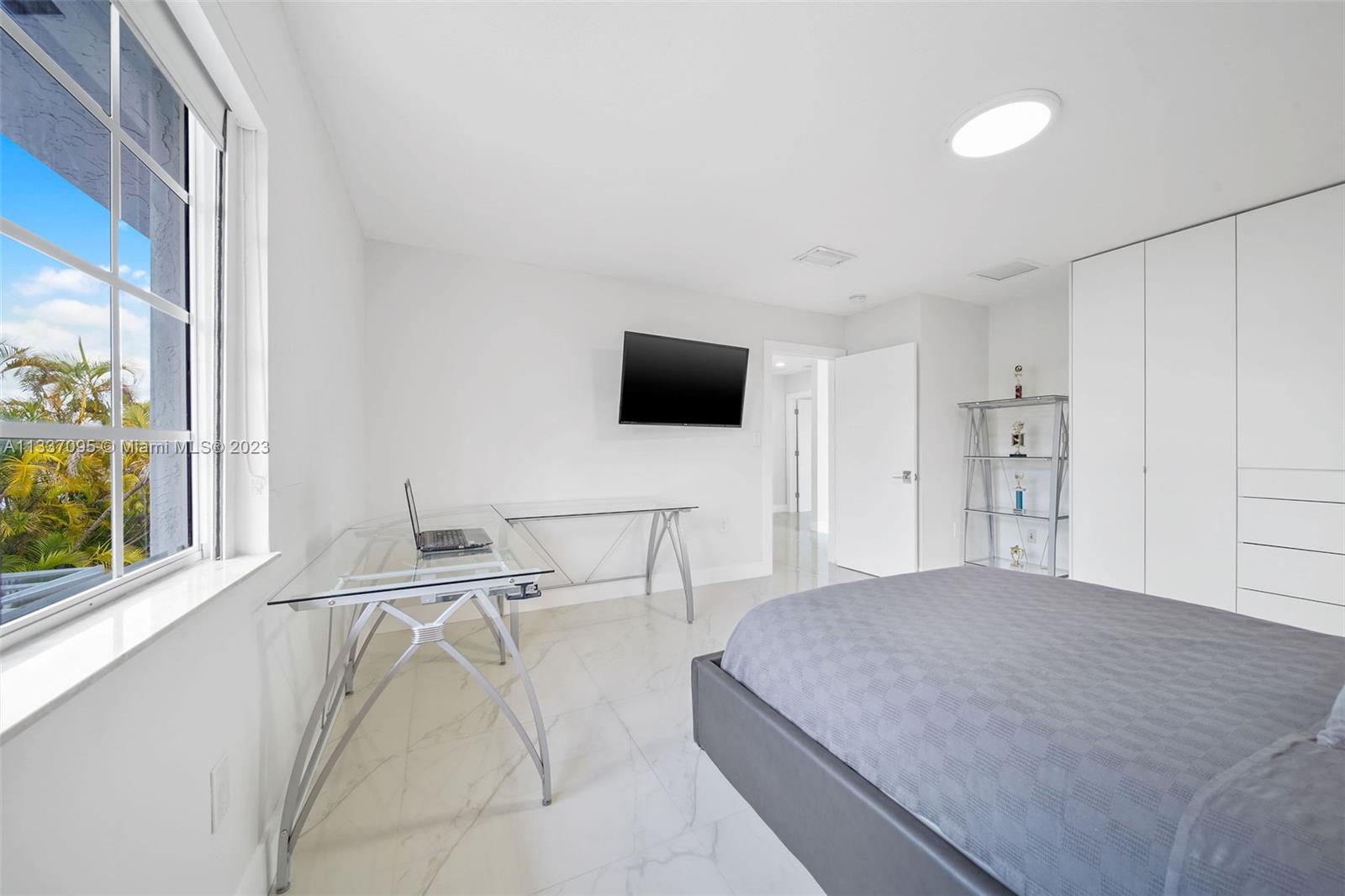 3436 Southwest 88th Place Miami, FL 33165 - Photo 37 of 43 a bedroom with a bed and a flat tv screen next to a window