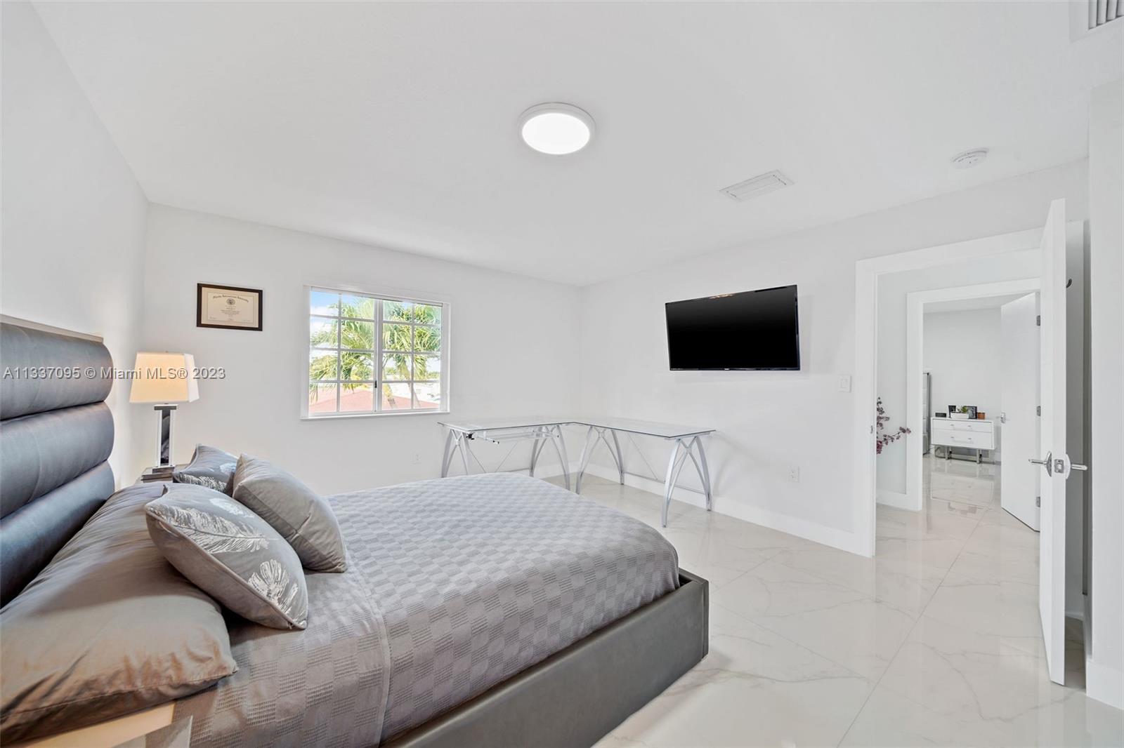 3436 Southwest 88th Place Miami, FL 33165 - Photo 38 of 43 a bedroom with a bed and a flat screen tv