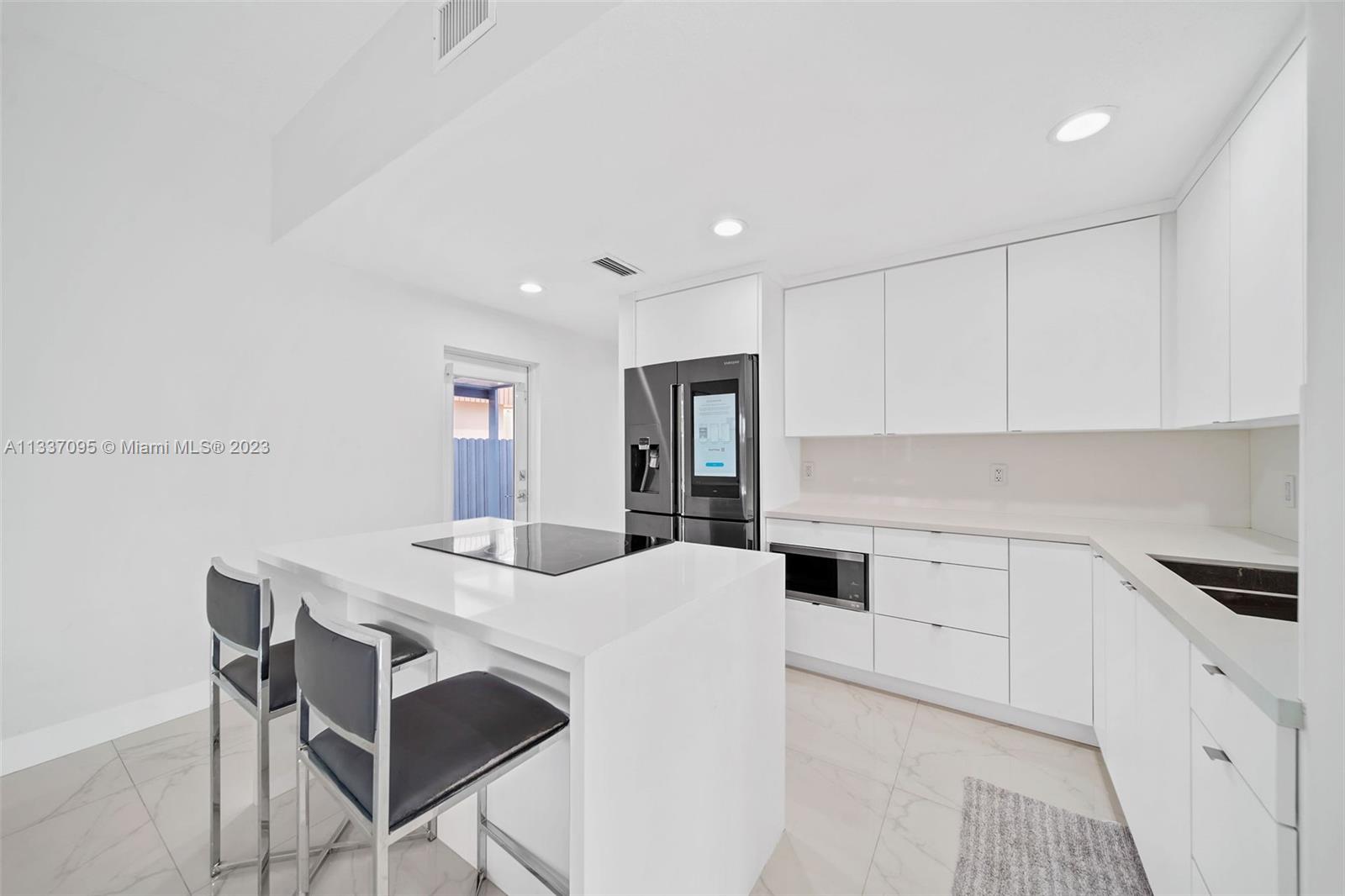 3436 Southwest 88th Place Miami, FL 33165 - Photo 10 of 43 a kitchen with stainless steel appliances kitchen island granite countertop a sink and cabinets