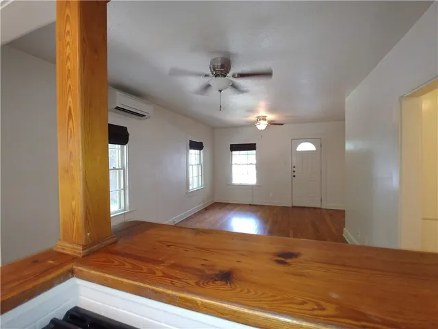 a view of empty room with window and ceiling fan