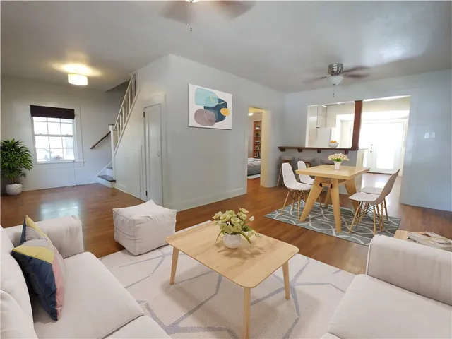 a living room with furniture and a wooden floor