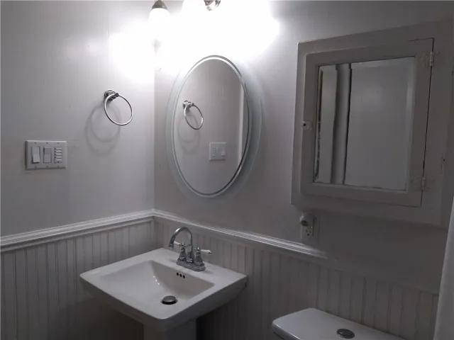 a bathroom with a toilet sink and mirror