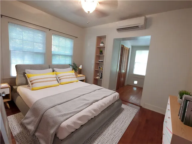a bedroom with a bed and wooden floor