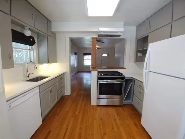 a kitchen with a sink a refrigerator and a stove top oven