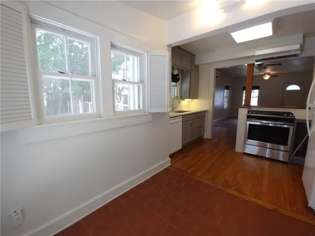 an empty room with a fireplace and windows