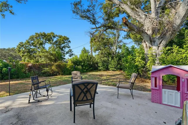 a view of a chairs and table in the back yard of the house