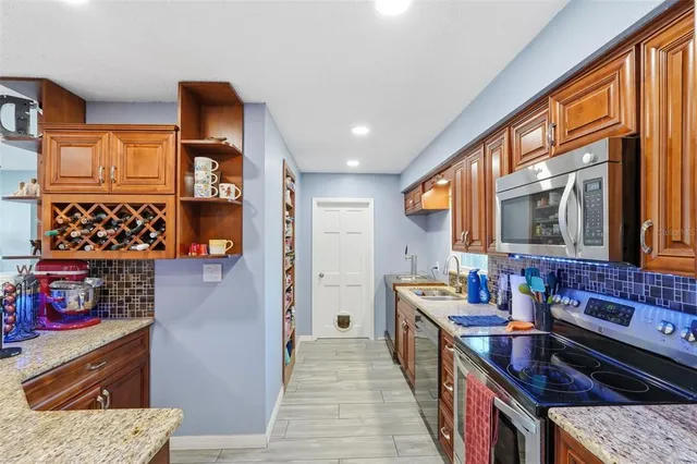 a kitchen with stainless steel appliances granite countertop a stove a sink and a refrigerator