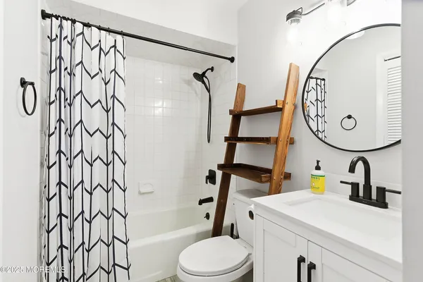 a bathroom with a sink a toilet and a mirror