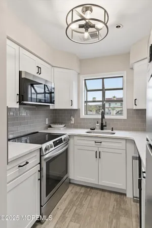 a kitchen with a stove cabinets and window