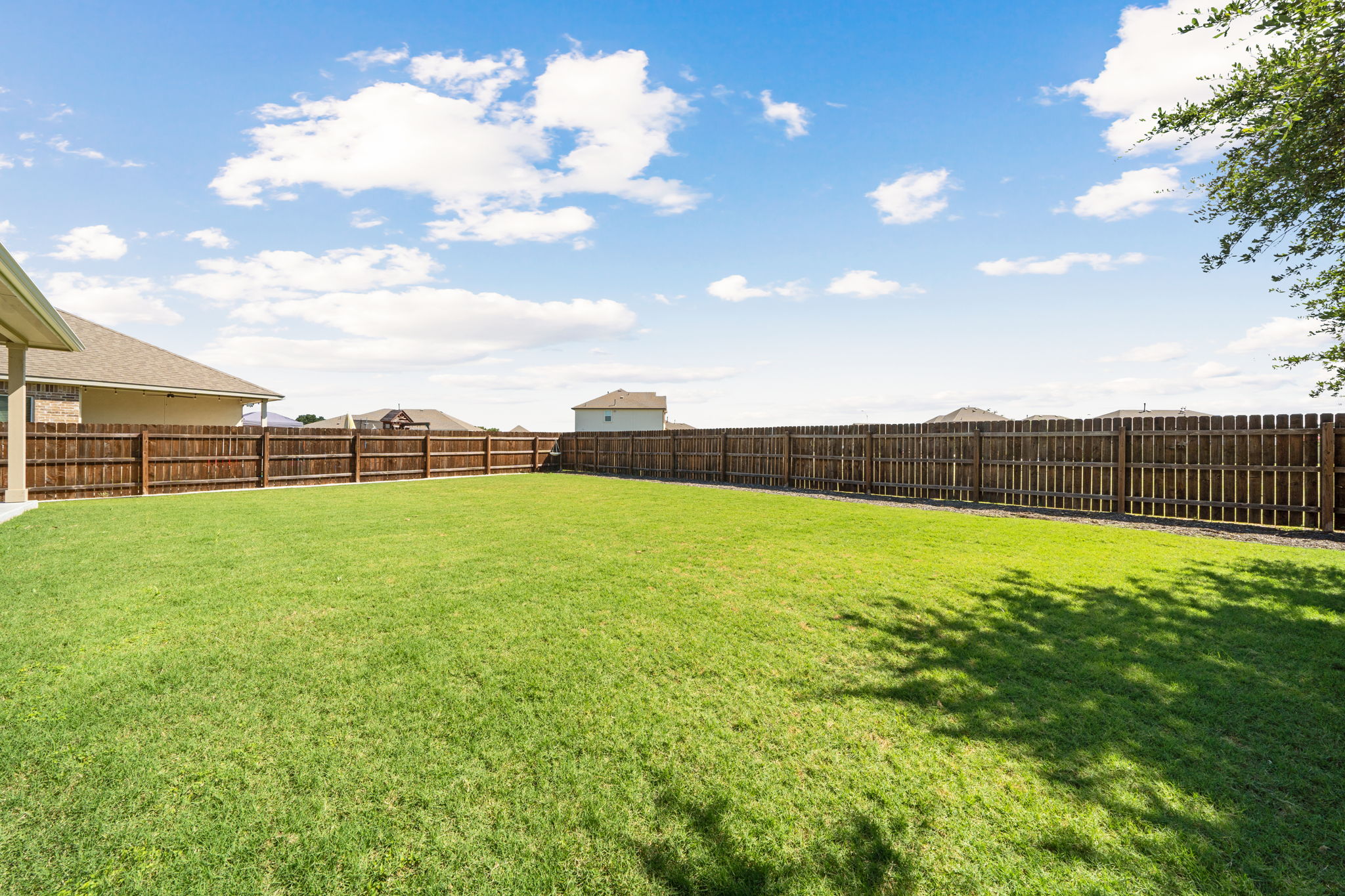 2412 Starhill Ranch Street Georgetown, TX 78628 - Photo 39 of 40 A spacious backyard with vibrant green grass, fully enclosed by a sturdy privacy fence.