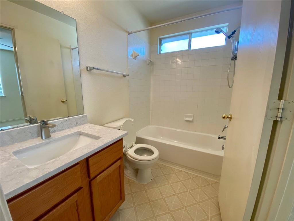512 Celery Loop Austin, TX 78748 - Photo 13 of 26 a bathroom with a sink a toilet a mirror a bathtub and shower