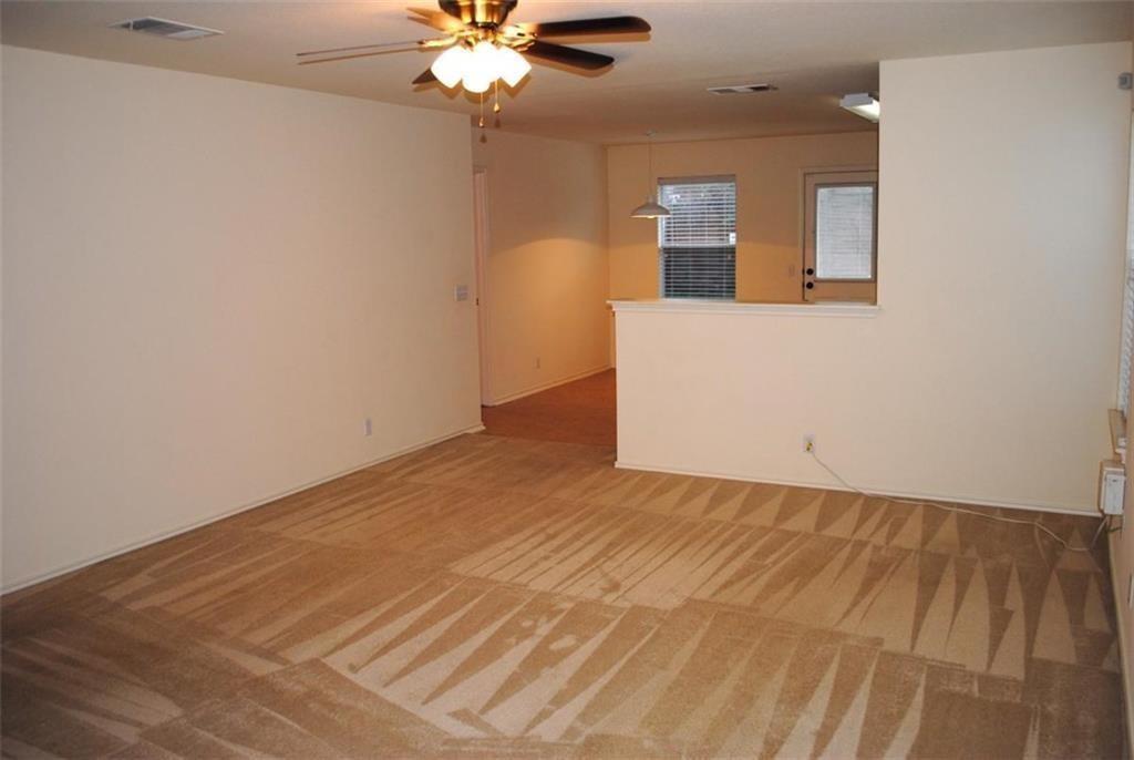 512 Celery Loop Austin, TX 78748 - Photo 16 of 26 an empty room with a chandelier fan and wooden floor