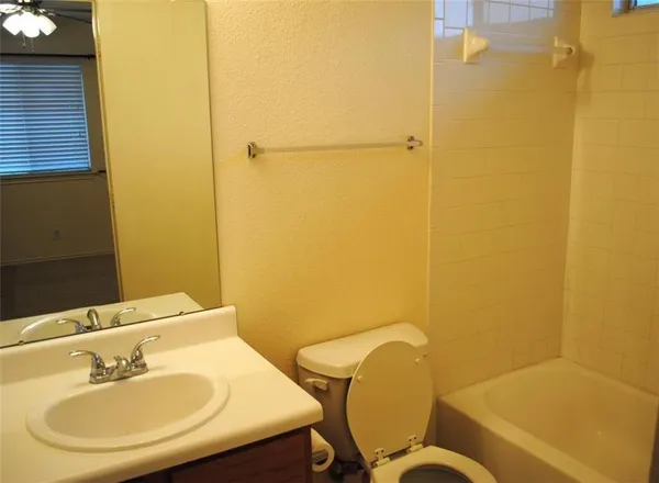 a bathroom with a sink mirror and toilet
