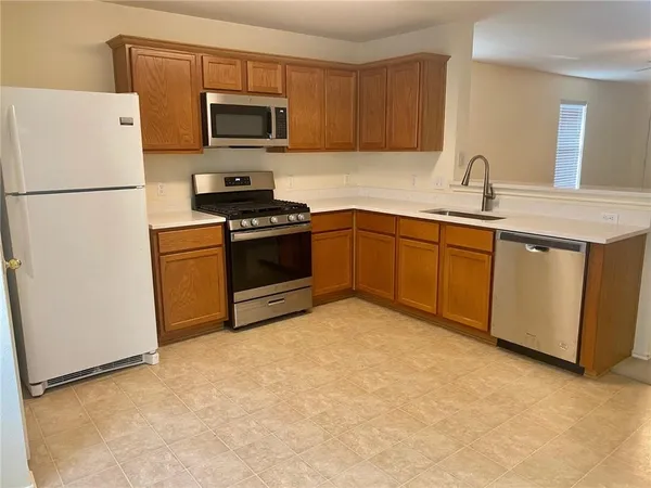 a kitchen with stainless steel appliances granite countertop a refrigerator stove a sink and dishwasher