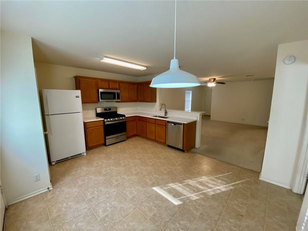 512 Celery Loop Austin, TX 78748 - Photo 6 of 26 a kitchen with stainless steel appliances a refrigerator and a stove top oven