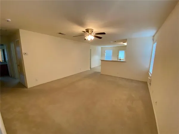an empty room with a ceiling fan and a window