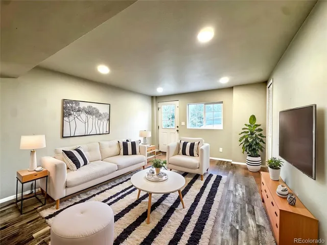 a living room with furniture a large window and a flat screen tv