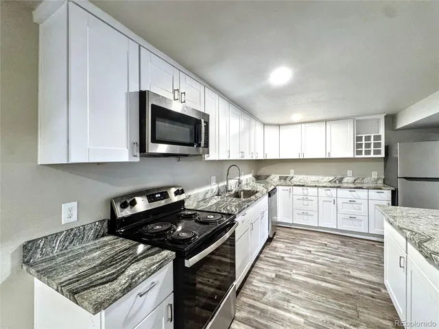 a kitchen with a sink stove top oven and refrigerator