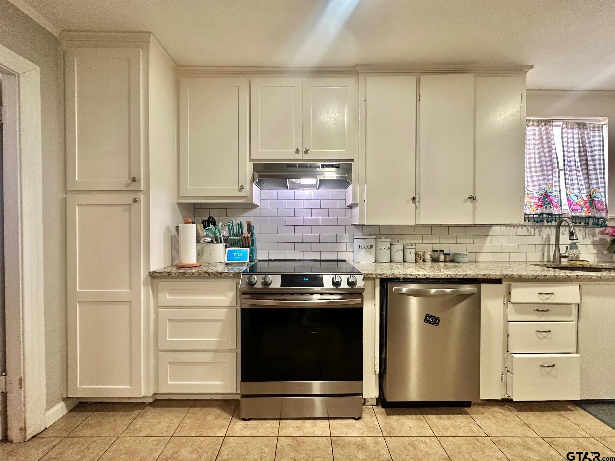 2601 East George Richey Road Longview, TX 75604 - Photo 15 of 26 a kitchen with granite countertop white cabinets and stainless steel appliances