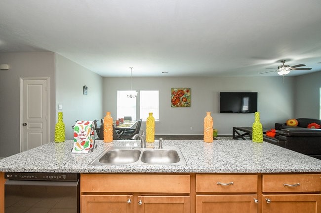 3318 Grand Cane Lane Rosenberg, TX 77471 - Photo 7 of 19 a kitchen with granite countertop a sink a counter top space and living room