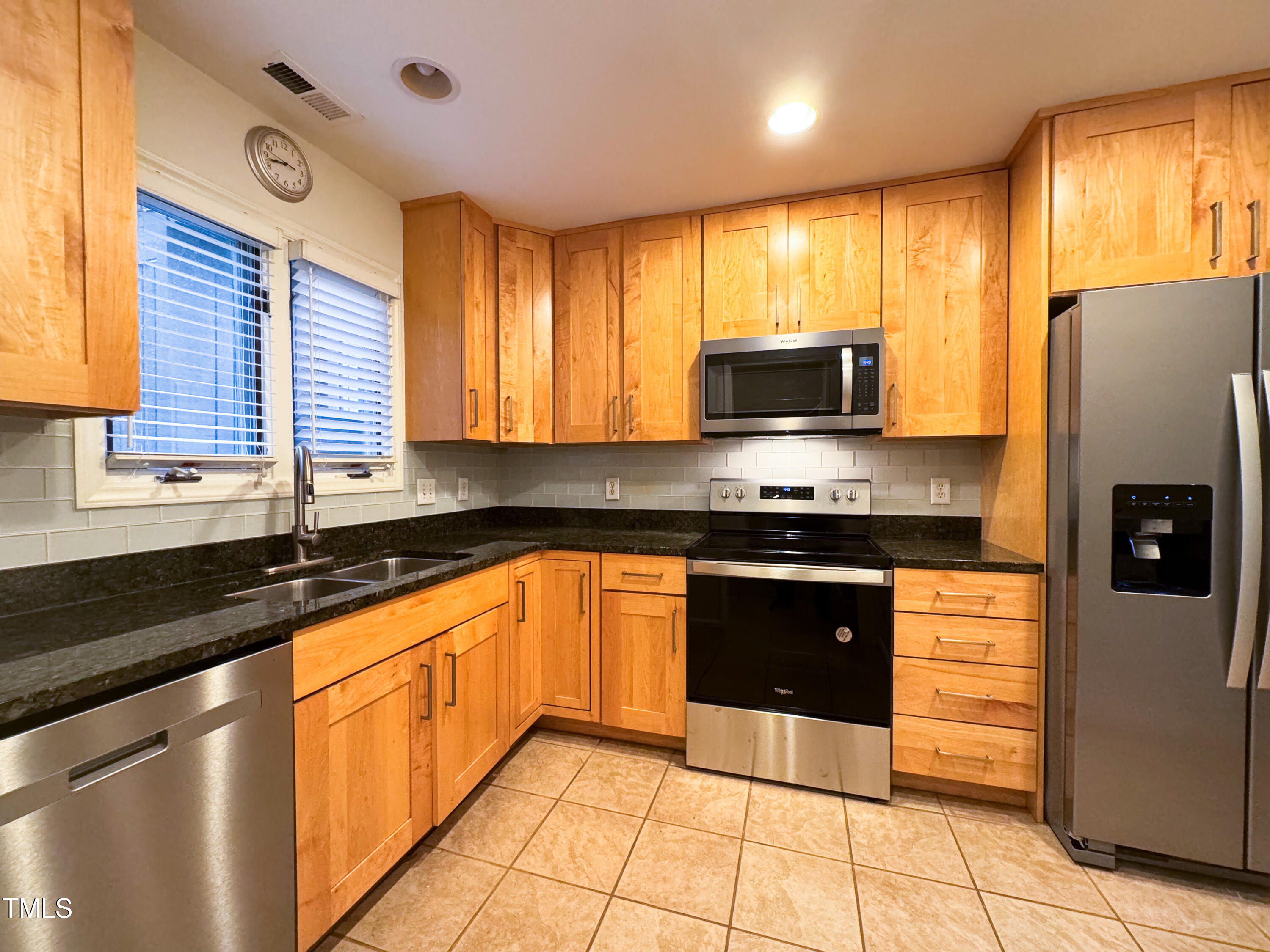 4221 Sunscape Lane Raleigh, NC 27613 - Photo 3 of 29 a kitchen with granite countertop a refrigerator stove top oven and sink