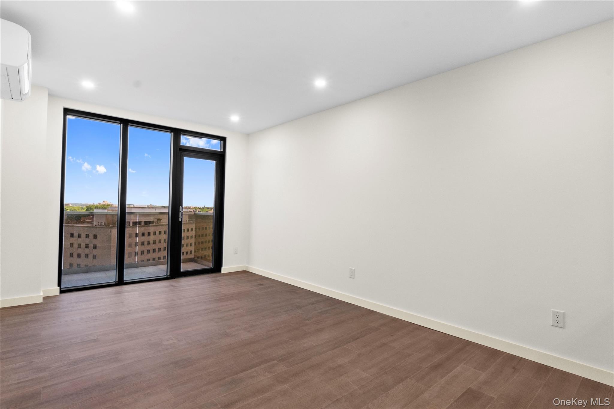 124-28 Queens Boulevard, Unit 12C Queens, NY 11415 - Photo 3 of 14 Unfurnished room featuring recessed lighting, dark wood finished floors, and a wall mounted air conditioner
