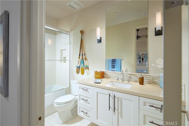 a bathroom with a sink toilet vanity and tub