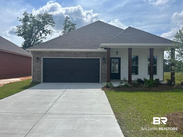 976 Ashville Circle Foley, AL 36535 - Photo 1 of 3 Single story home with a front lawn, roof with shingles, an attached garage, driveway, and a porch