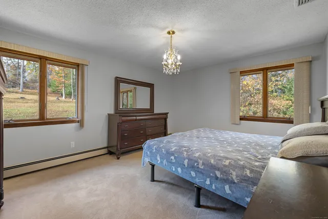 a bedroom with a bed and a dresser next to a window