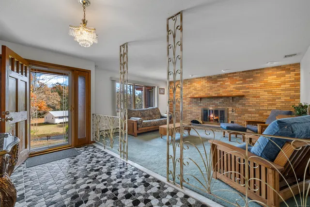 a living room with fireplace furniture and a large window