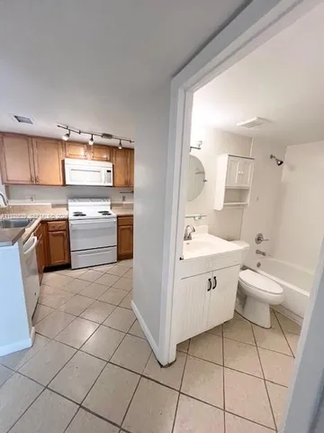 a large white kitchen with a stove a sink dishwasher and a refrigerator