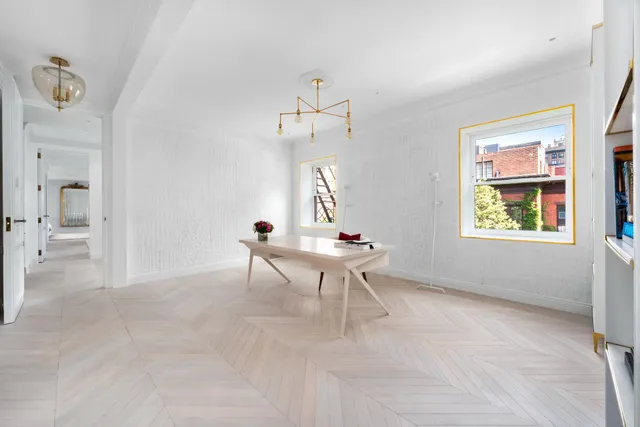 a view of a living room with a table and chairs