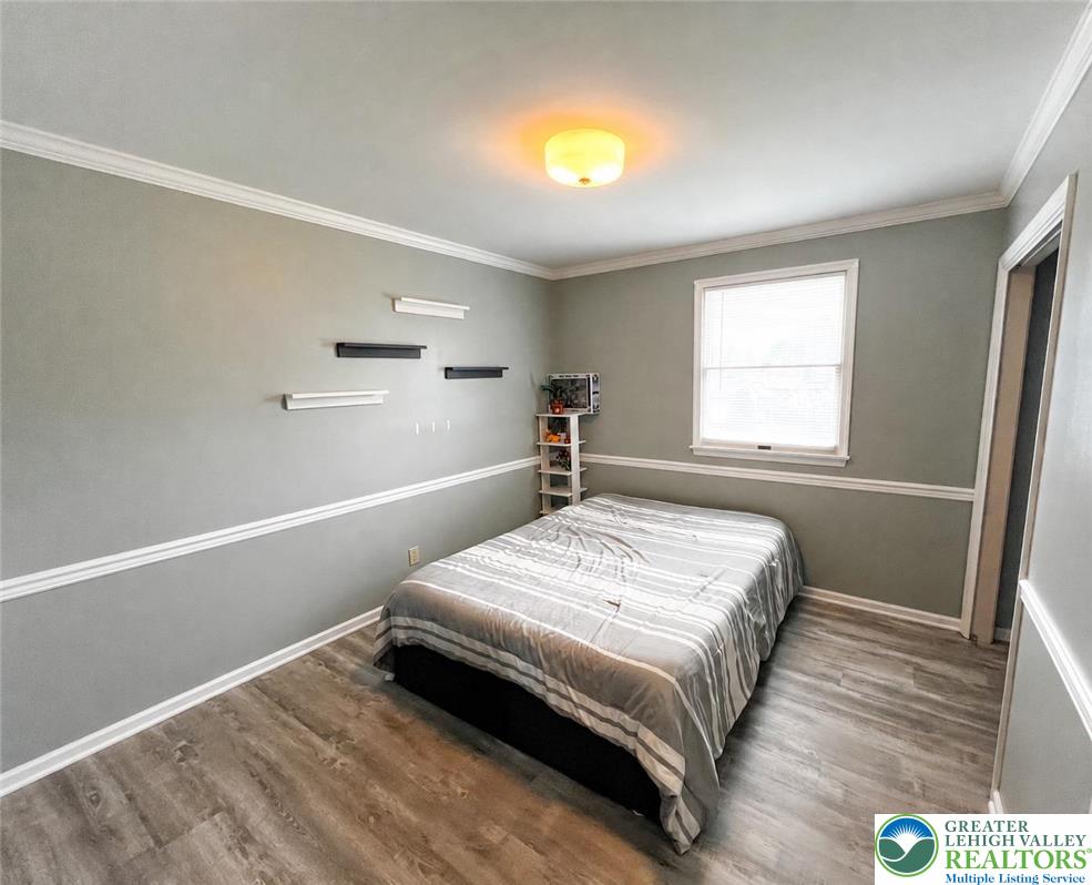 10 Dusty Road Easton, PA 18045 - Photo 29 of 35 A comfortable bedroom features light gray walls, white trim, and resilient laminate flooring.