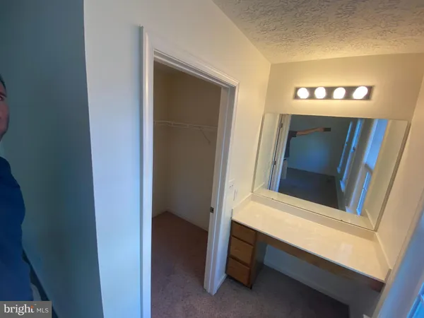a bathroom with a sink and mirror with bathtub