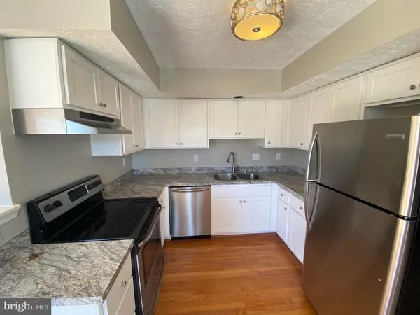 a kitchen with a sink a stove a refrigerator and a window