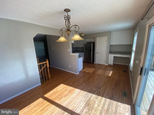 a kitchen with a sink wooden floor and stainless steel appliances
