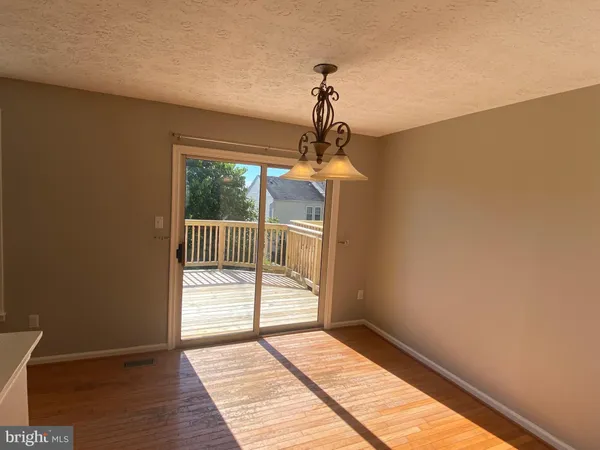 a view of a livingroom with wooden floor and a ceiling fan
