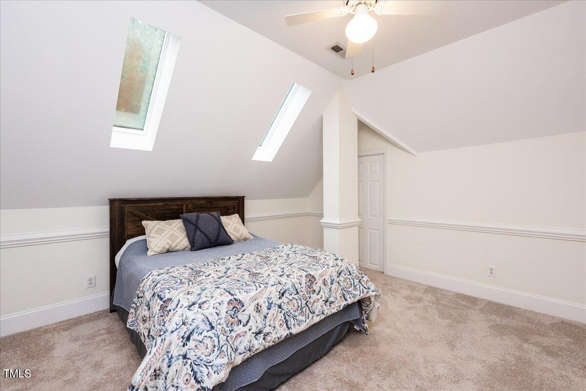 6916 Pinnacle Ridge Road Raleigh, NC 27603 - Photo 33 of 56 a bedroom with a large bed and a chandelier