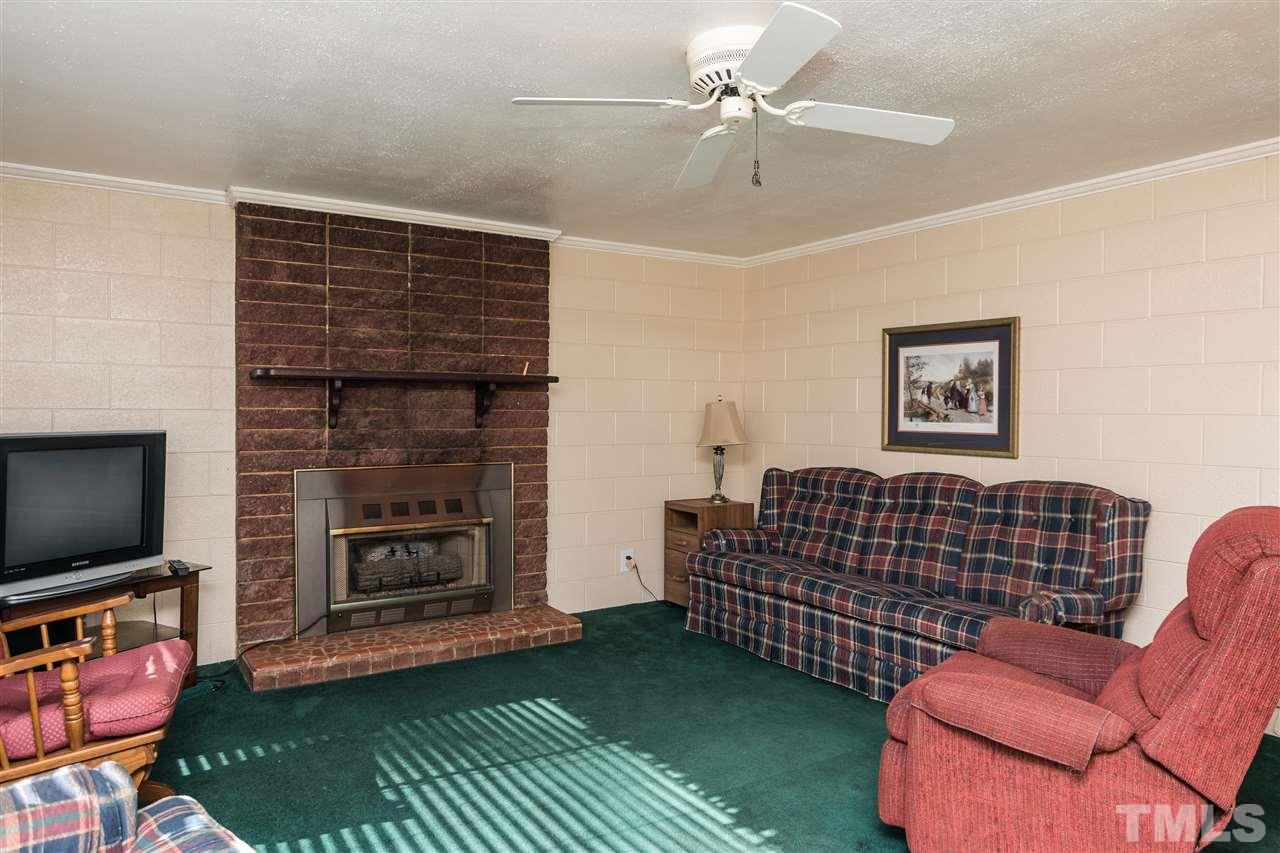 1016 Legend Road Raleigh, NC 27603 - Photo 3 of 21 a living room with furniture a flat screen tv and a fireplace