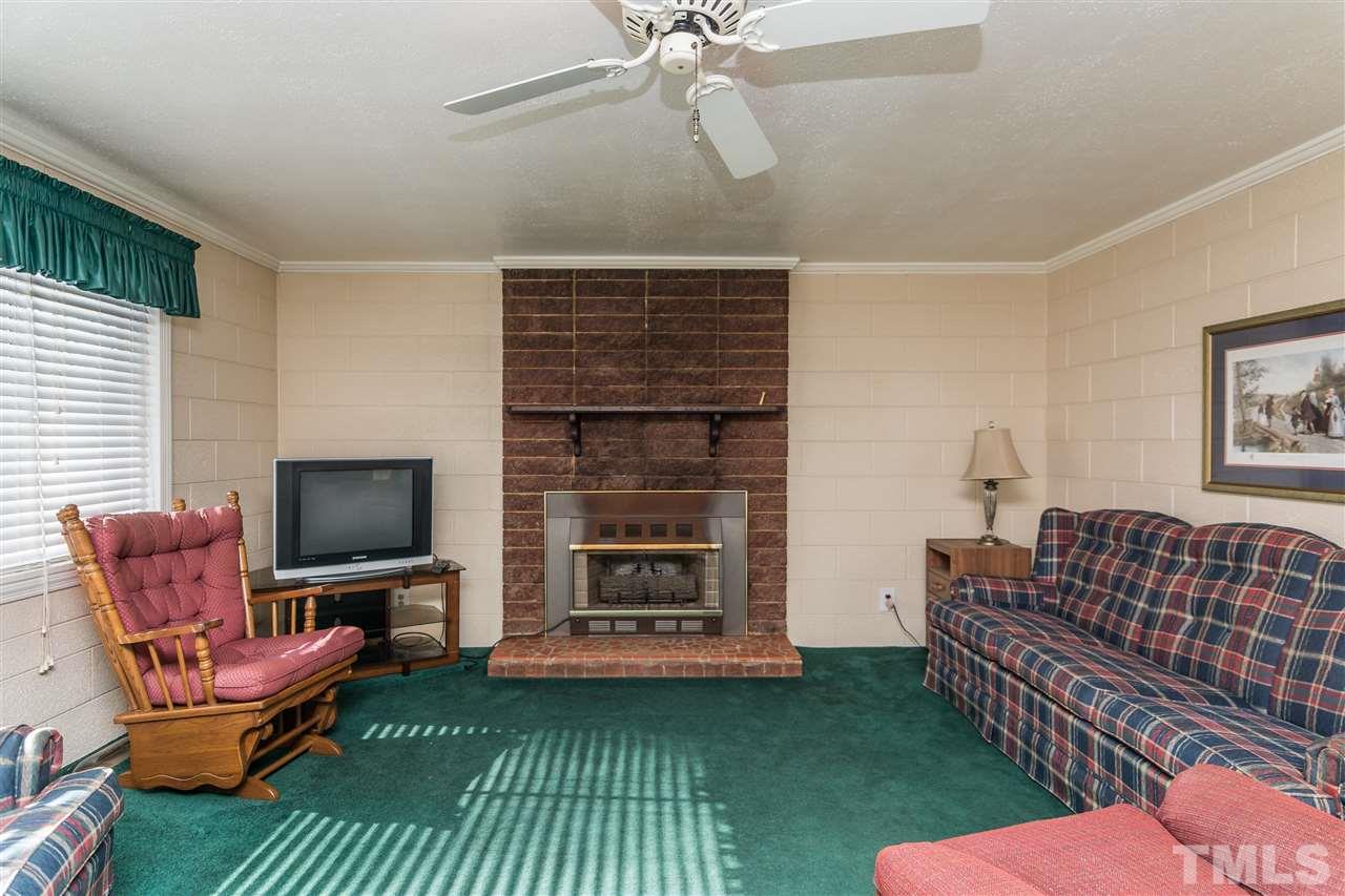 1016 Legend Road Raleigh, NC 27603 - Photo 6 of 21 a living room with furniture a flat screen tv and a fireplace