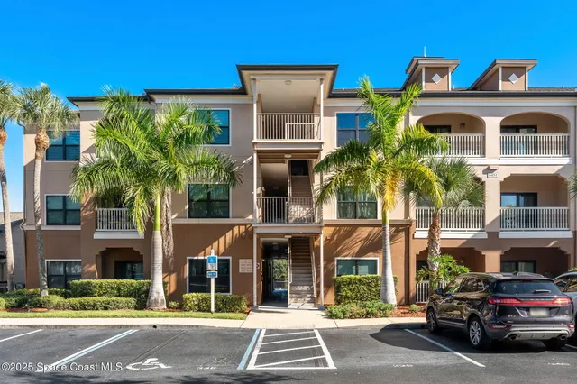 a front view of a building with a garden and plants