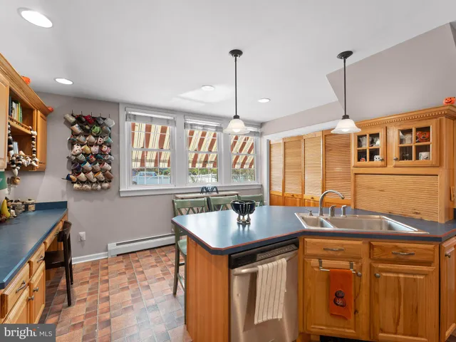 a kitchen with stainless steel appliances granite countertop a sink a stove and a wooden cabinets